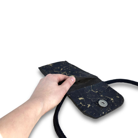 KEDJA deluxe Umhängetasche in anthrazit-schwarz mit Sicht auf das geöffnete Fach und Hand, ideal für Motorola Moto G86